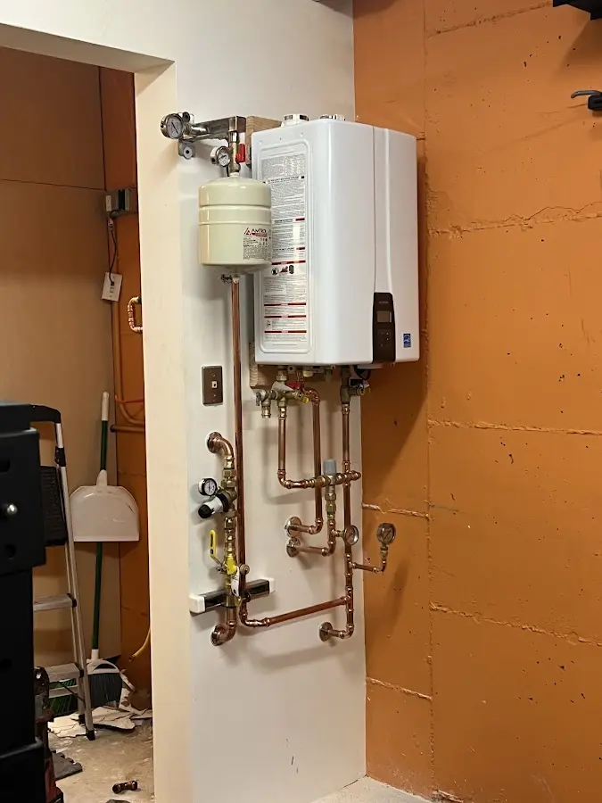 Plumbing technician inspecting water heater connections in Laurel Hill